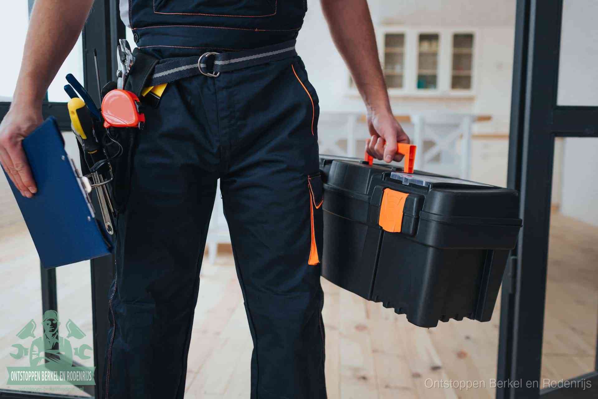 Een monteur met gereedschapsriem en klembord in een keuken, klaar om een transparante prijs voor het gootsteen ontstoppen in Berkel en Rodenrijs te geven