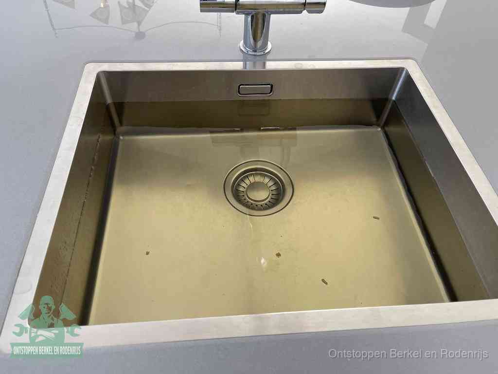 Stilstaand water in een rvs spoelbak dat niet wegloopt, een duidelijk signaal van een gootsteenverstopping in Berkel en Rodenrijs